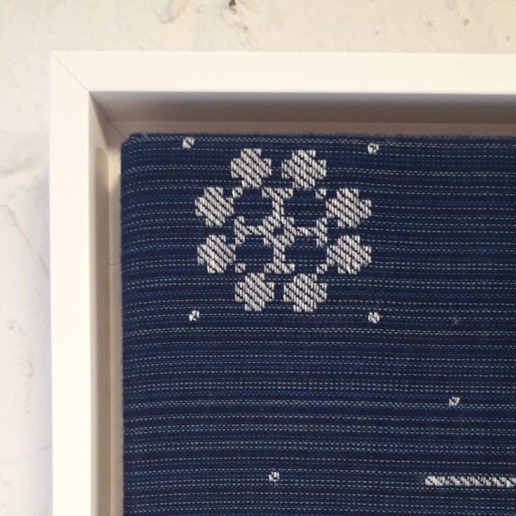 The picture shows a white wooden frame with which the work is framed.