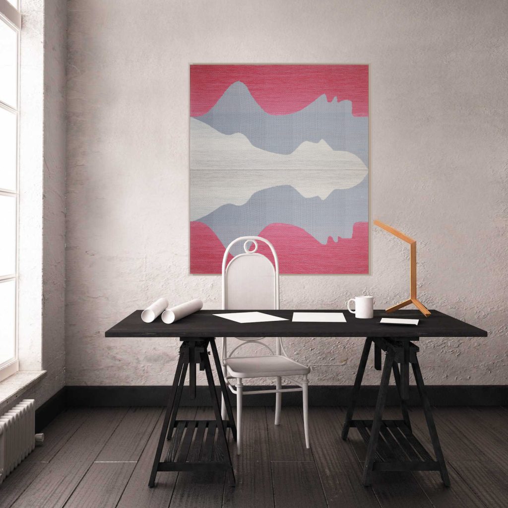 The photo shows a textile artwork hung on the wall of the office space.